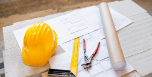 Casque de chantier, plans et outils de mesure préparés avant une intervention toiture